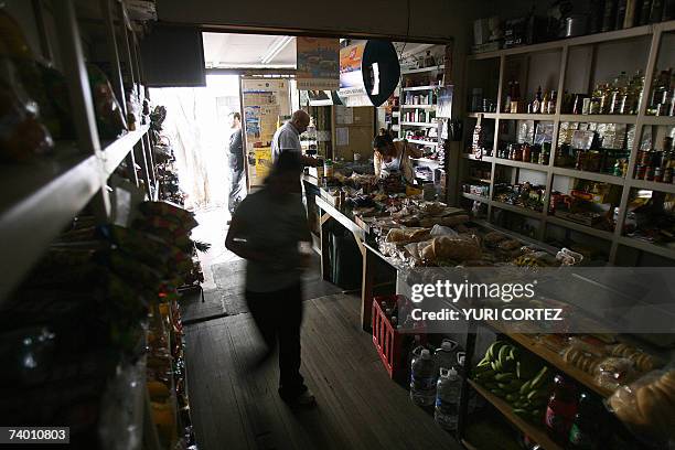 Una mujer busca algunos productos en la estanteria de una tienda 27 de abril de 2007 durante un corte de energia electrica en San Jose. Los...