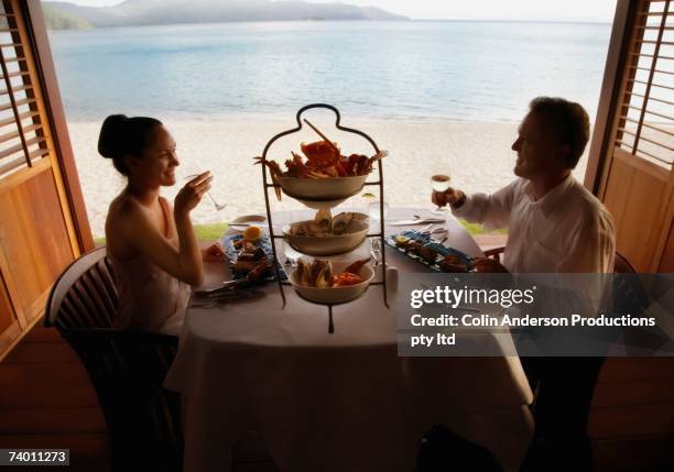 couple eating next to beach - tropical queensland stock pictures, royalty-free photos & images