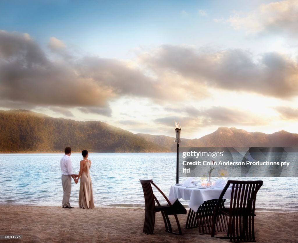 Couple next to table set for two at beach