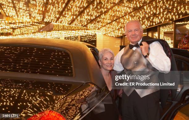 Senior Couple In Formal Wear Getting Out Of Limousine, Foto de stock