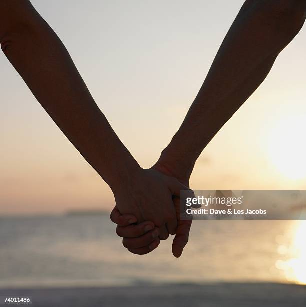 close up of couple holding hands - holding hands close up stock-fotos und bilder
