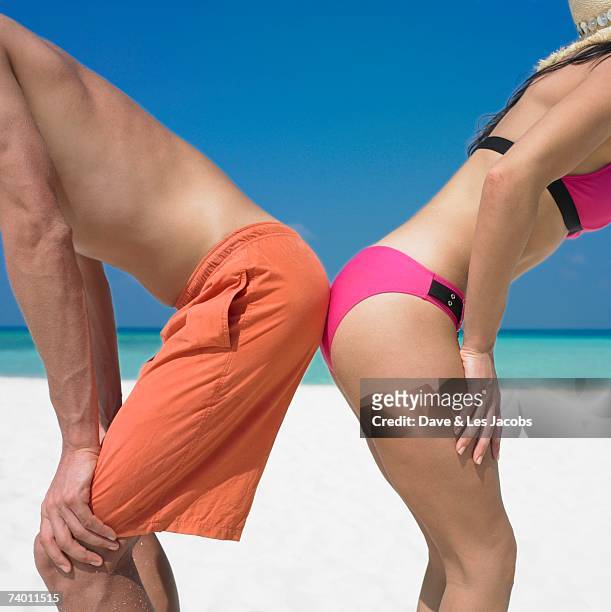 couple touching rear ends at beach - beach bum stock pictures, royalty-free photos & images