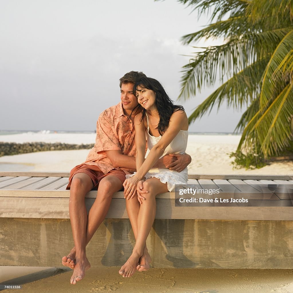 Couple sitting on beach boardwalk
