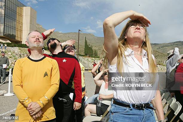 Alamogordo, UNITED STATES: Star Trek fans Anna Hamilton of Santa Fe, New Mexico, father and son fans Will and Jared Steinsiek watch a missing man...