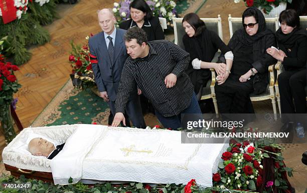 Moscow, RUSSIAN FEDERATION: A man touches a coffin as Galina Vishnevskaya , the widow and daughters Yelena and Olga sit near the coffin of Mstislav...