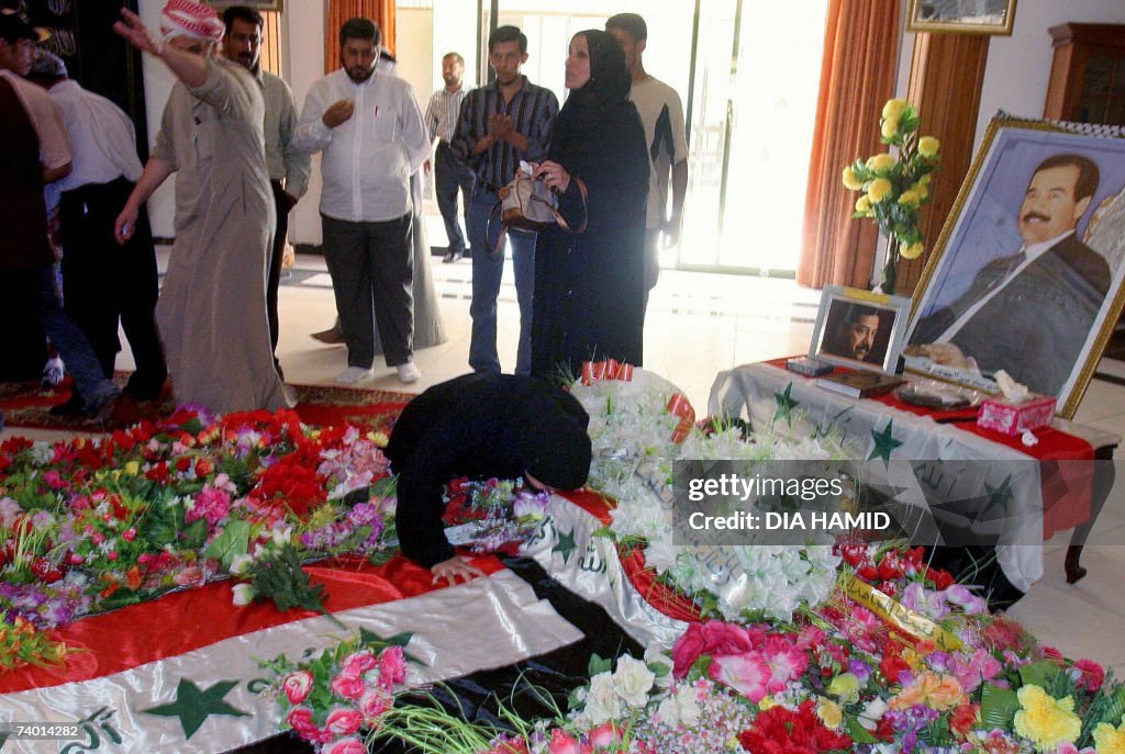 An Iraqi woman kisses the tomb of execut...