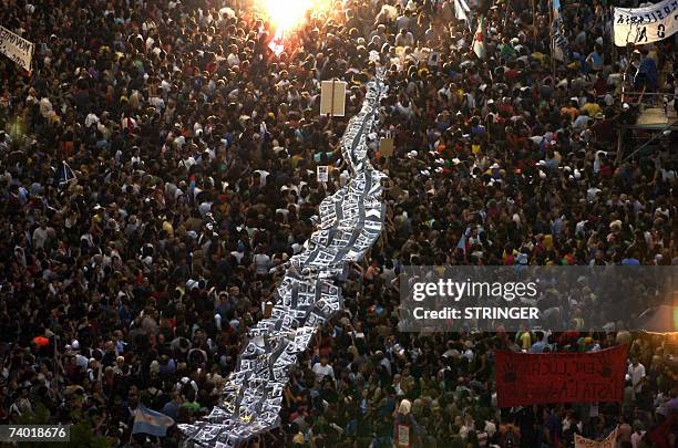 Buenos Aires, ARGENTINA: Thousands of demonstrators led by "Madres de Plaza de Mayo" human rigths organization, hold a big banner with pictures of...