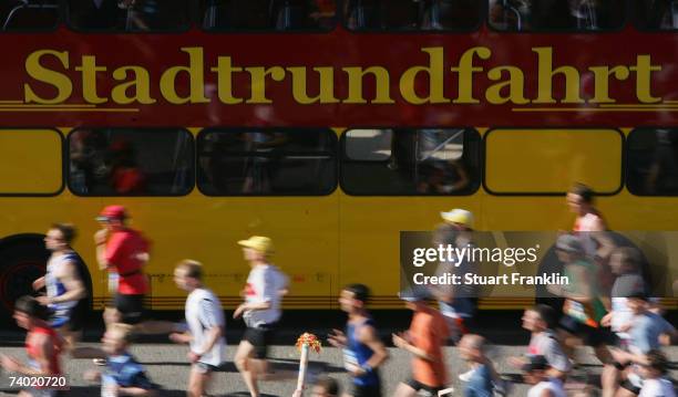 The runners pass by a bus that offers around the city trips by Landungsbrucken during the Hamburg Conergy Marathon on April 29, 2007 in Hamburg,...