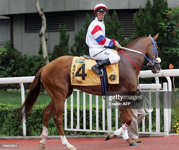 Jockey Kevin Shea riding on horse Sushisan from South Africa is led to the race track prior to the Audermars Piguet QE II cup at Sha Tin race course...
