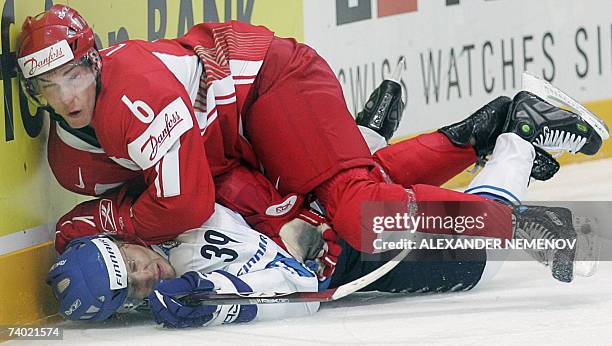 Moscow, RUSSIAN FEDERATION: Finnish Niko Kapanen fights with Danish Stefan Lassen during preliminary round group D game of the IIHF Internetional Ice...