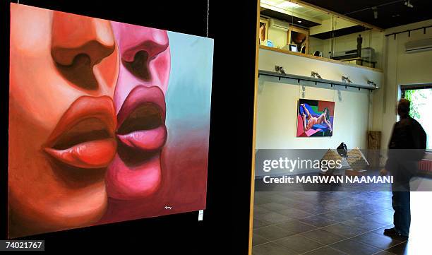 Lebanese man looks at paintings by young Lebanese artists Maria Sarkis and Nayala Karam exhibited at Suface Gallery in Beirut's Christian suburb of...