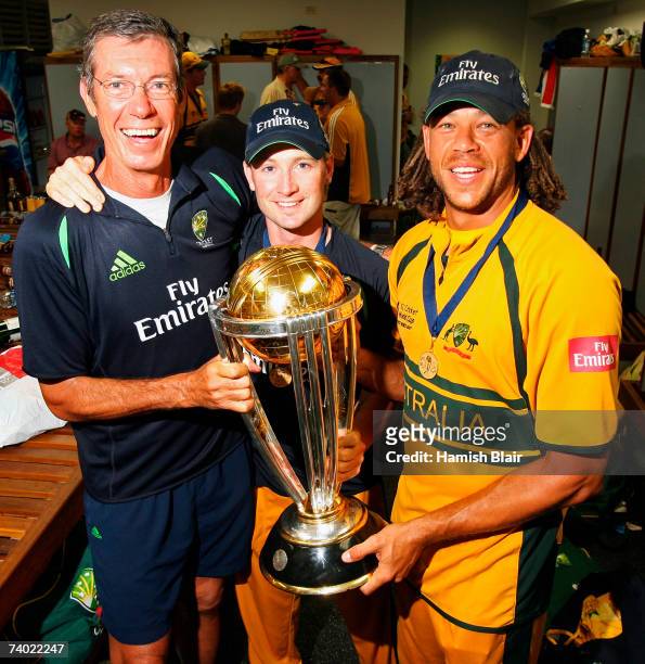 Coach John Buchanan, Michael Clarke and Andrew Symonds of Australia hold the ICC World Cup trophy in the changing rooms after the ICC Cricket World...