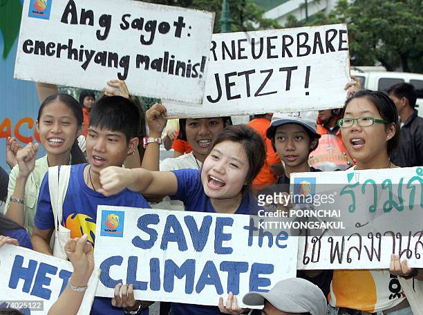 International students join a campaign organised by environment group Greenpeace as they shout slogans outside the location where the...
