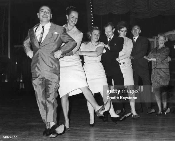 Big Bandleader Joe Loss introduces the Finnjenka, a Finnish version of the Conga, at the Hammersmith Palais, 22nd October 1964. He is publicising his...