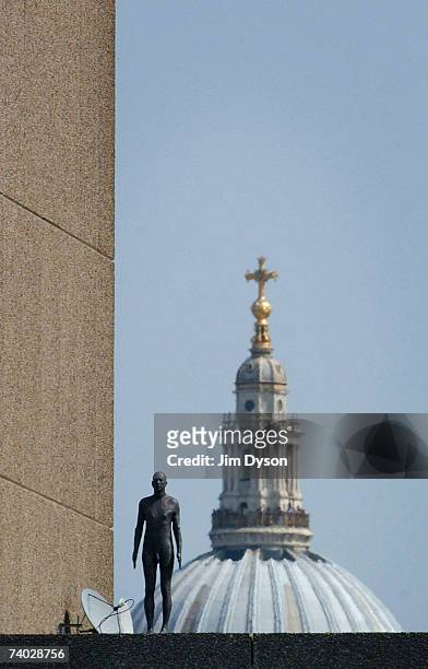 Life size body cast of the artist Antony Gormley stands on top of a building in central London as part of his new multi-figure installation 'Event...