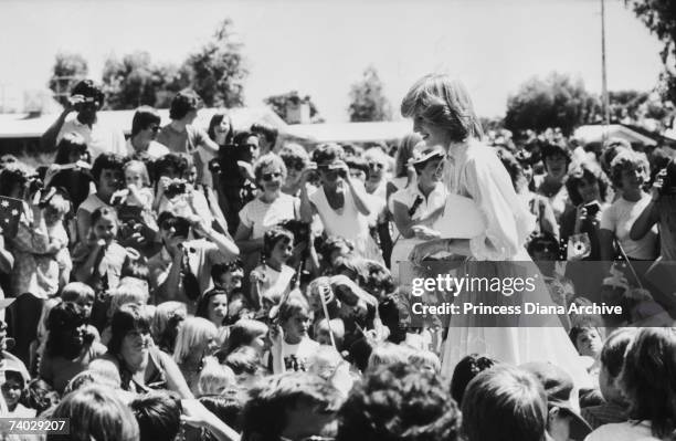 Princess Diana at the School of the Air, in Alice Springs, Australia, 30th March 1983. She is wearing a yellow dress by Jan van Velden.