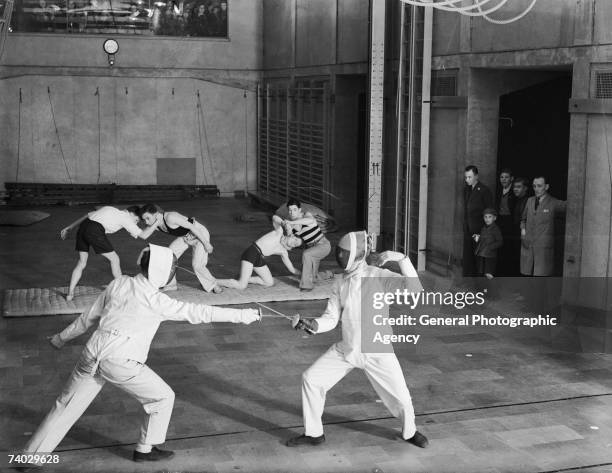 Wrestling and fencing sessions taking place in a gymnasium at the Pioneer Health Centre in Queens Road, Peckham, circa 1935. The centre was opened by...