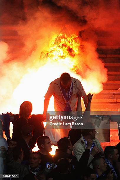 Fans of Rostock light a fire during the Second Bundesliga match between Rot Weiss Essen and Hansa Rostock at the Georg Melches stadium on April 30,...