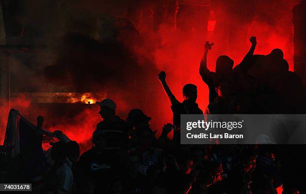 Fans of Rostock light a fire during the Second Bundesliga match between Rot Weiss Essen and Hansa Rostock at the Georg Melches stadium on April 30,...