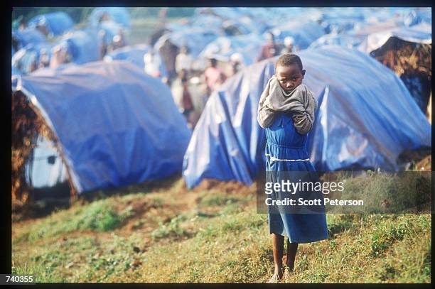Child dries her face June 24, 1994 at the Nyarushishi Tutsi refugee camp on the Zaire border in Gisenyi, Rwanda. The camp is run by Hutu prefect...