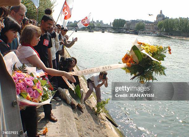 People throw flowers, 01 May 2007 close by the Carrousel bridge in Paris, in memory of young Moroccan Brahim Bouarram who was thrown into the Seine...