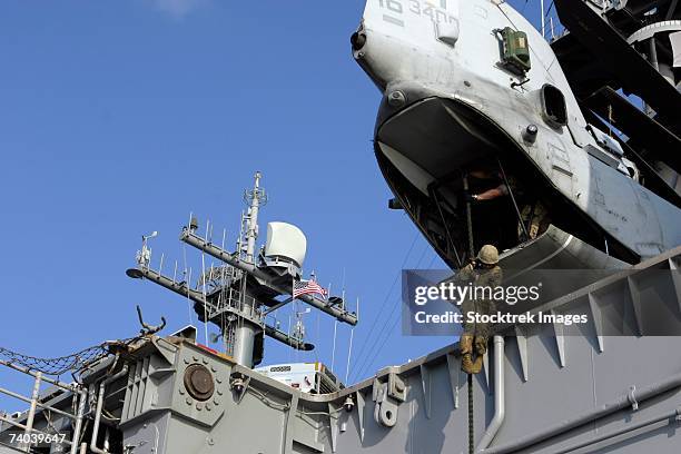 aboard uss essex a combat engineer with company g fast-ropes from the rear of a ch-46e sea knight helicopter may 9 which is parked overhanging the edge of the flight deck here. - boeing stock pictures, royalty-free photos & images