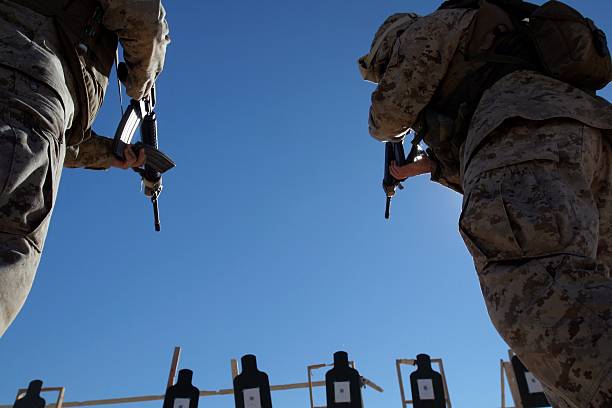 Two Marines with Marine Wing Support Squadron 374, Marine Wing Support Group 37, 3rd Marine Aircraft Wing, change magazines in the midst of firing during the Enhanced Marksmanship Course December 5 at Marine Corps Air Station Yuma, Arizona.