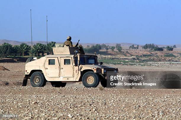 a vehicle filled with marines conducting a mounted combat patrol near al asad, iraq, june 15, sits at one of its checkpoints, observing the area briefly before moving on. - scanning awareness reconnaisance stockfoto's en -beelden