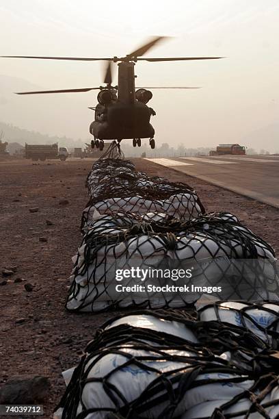 muzaffarabad, pakistan - marine landing support specialists attached to the combined medical relief team 3's helicopter support team, attach external loads, or sling loads, to the body of an army ch-47 chinook cargo helicopter, december 27. - boeing vertol chinook fotografías e imágenes de stock