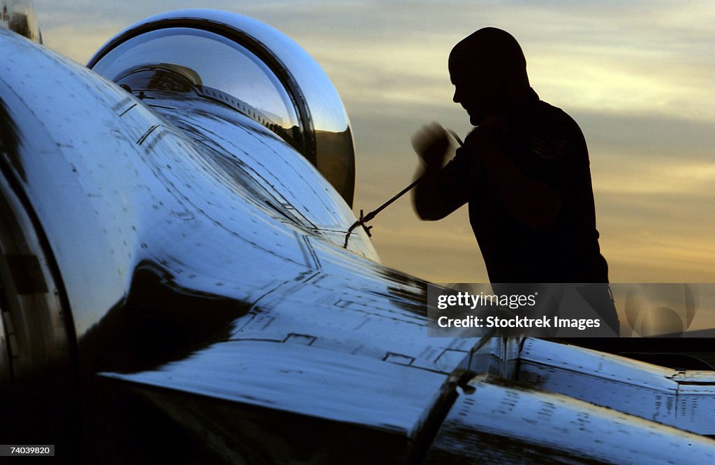 Airman tightens down an F-16 Fighting Falcon canopy after a periodic inspection at Nellis Air Force Base, Nevada. The U.S. Air Force Thunderbirds perform more than 65 shows annually across the United States and abroad.