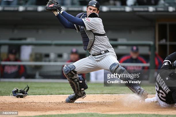 Joe Mauer of the Minnesota Twins fields the throw and attempts to tag Scott Podsednik during the game against the Chicago White Sox at U.S. Cellular...