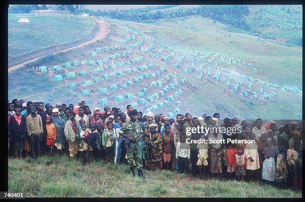 Hutu guard keeps the crowd back June 24, 1994 at the Nyarushishi Tutsi refugee camp on the Zaire border in Gisenyi, Rwanda. The camp is run by Hutu...