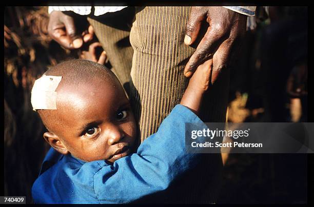 Child clings to her guardian June 24, 1994 at the Nyarushishi Tutsi refugee camp on the Zaire border in Gisenyi, Rwanda. The camp is run by Hutu...