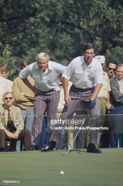Jack Nicklaus of the United States team looks on as American golfer Dave Stockton checks the position of his ball on a green during play on the first...