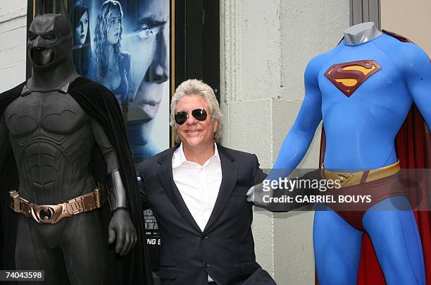 Hollywood, UNITED STATES: Hairdresser and film producer Jon Peters poses with Batman and Superman characters after being honored with a star on the...