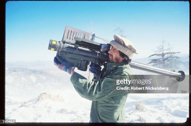 Guerrilla soldier aims a stinger missle at passing aircraft near a remote rebel base in the Safed Koh Mountains February 10, 1988 in Afghanistan. A...