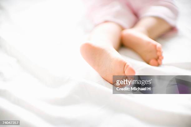 baby girl (15-18 months) lying on bed, close up of feet - bebe 1 a 2 años fotografías e imágenes de stock
