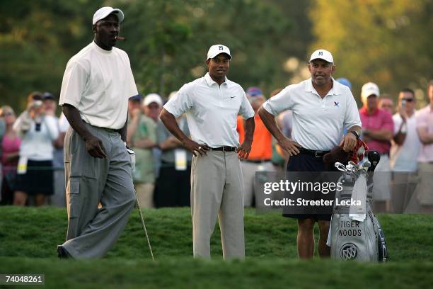 Tiger Woods and caddie Steve Williams look over at basketball star Michael Jordan on the 6th tee during the Pro-am at the Wachovia Championship at...