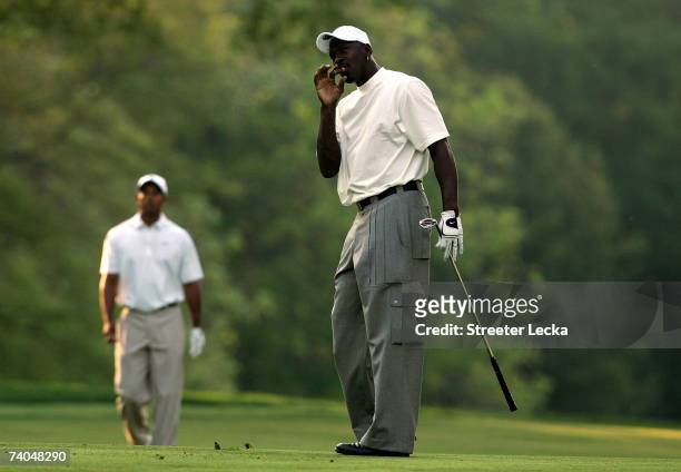Tiger Woods watches basketball star Michael Jordan on the 4th fairway during the Pro-am at the Wachovia Championship at Quail Hollow Country Club on...
