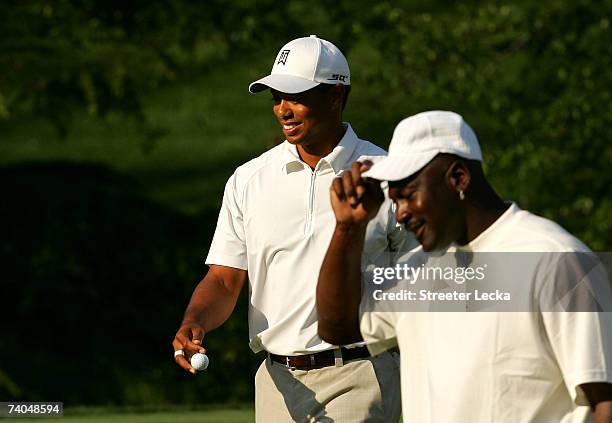 Tiger Woods and Michael Jordan smile to the crowd as they walk off the 7th green during the Pro-am at the Wachovia Championship at Quail Hollow...