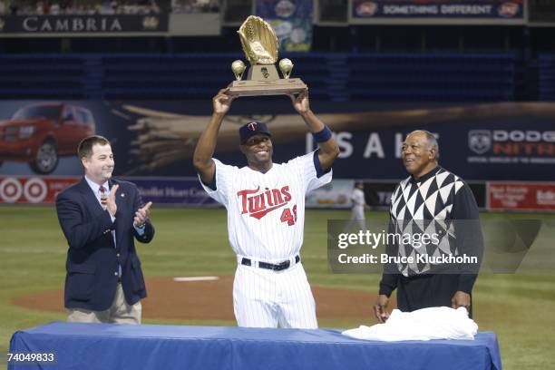 Torii Hunter of the Minnesota Twins hoists his 2006 Golden Glove award with Rawlings representative Dan Phelps and Tony Oliva in a pre-game ceremony...