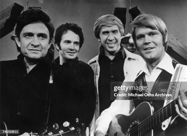 Country musician Johnny Cash, Merle Haggard, Buck Owens and Glen Campbell perform on stage during a mid 1970's performance for a TV show.
