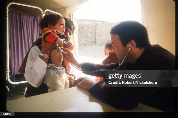 Doctor tends to a young child in a makeshift hospital near the Safed Koh mountains February 10, 1988 in Afghanistan. A Soviet-supported communist...