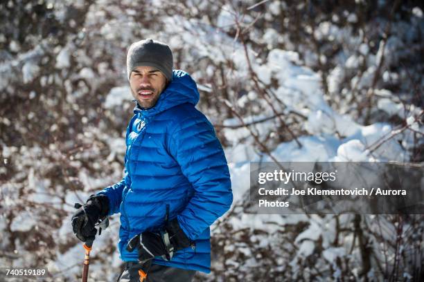man snowshoeing on sunny winter day - ski jacket stock pictures, royalty-free photos & images