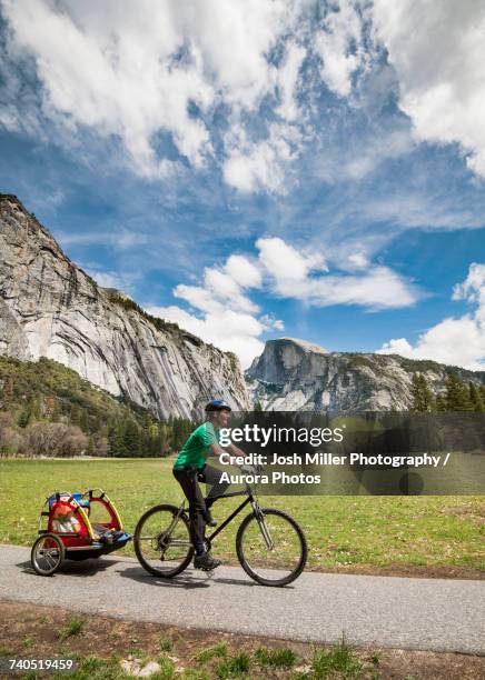 female tourist with kids in trailer riding bicycle in yosemite national park - yosemite valley 個照片及圖片檔