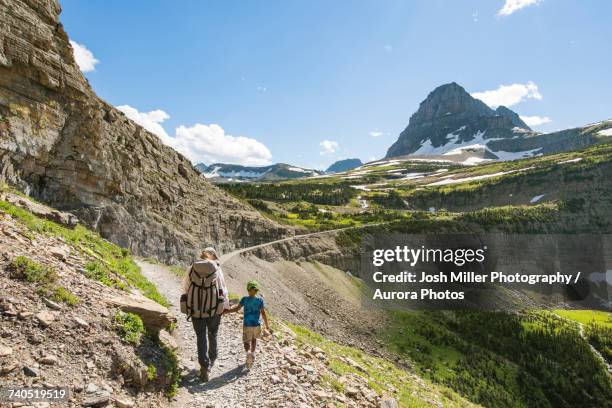 woman and child hiking in mountainous region - parque nacional glacier fotografías e imágenes de stock