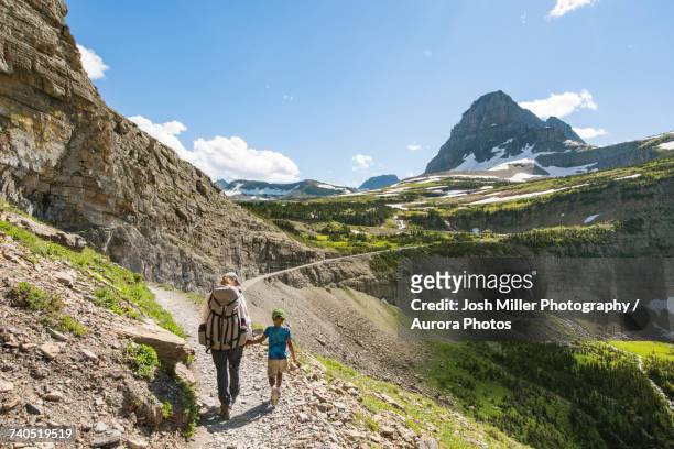 woman and child hiking in mountainous region - glacier national park foto e immagini stock