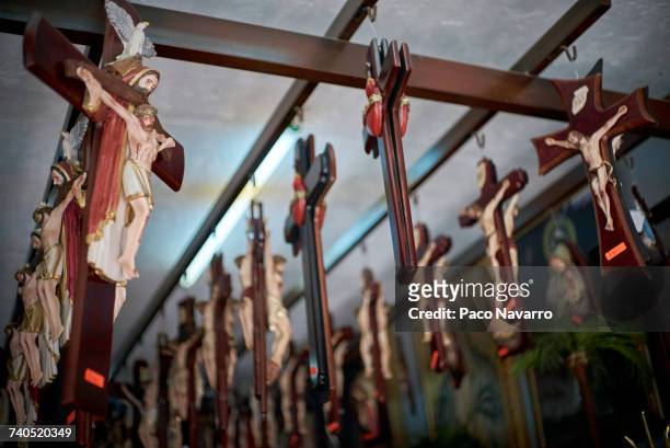 crucifixes handing on beams in shop - jesus christ photo stock pictures, royalty-free photos & images