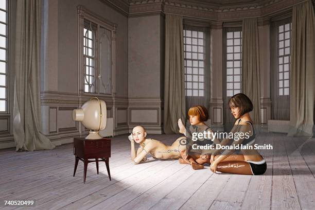 robot woman and girls laying on floor watching television - smart tv stock-fotos und bilder