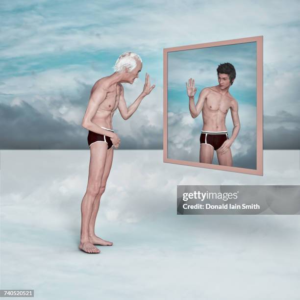 older man admiring image of younger man in virtual mirror - alter ego stock-fotos und bilder